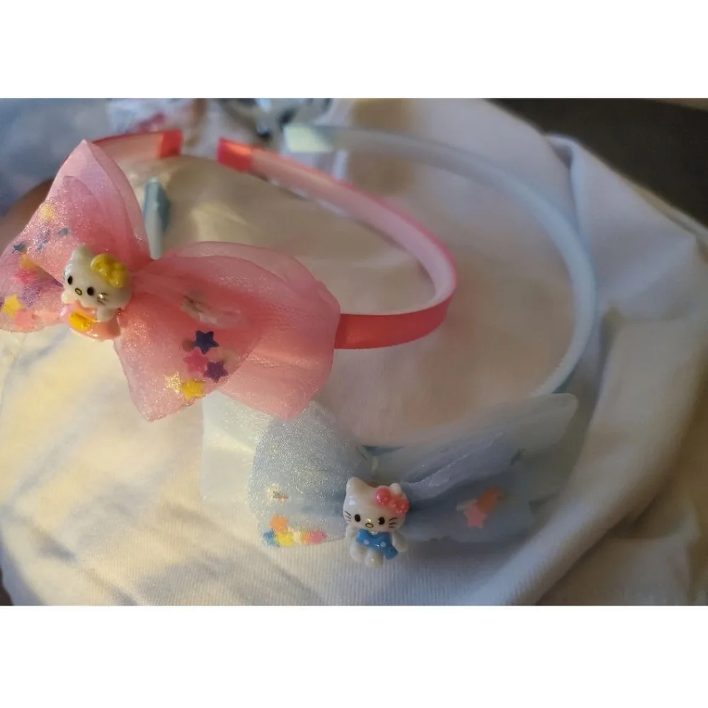 Four Hello Kitty headbands with small figurine